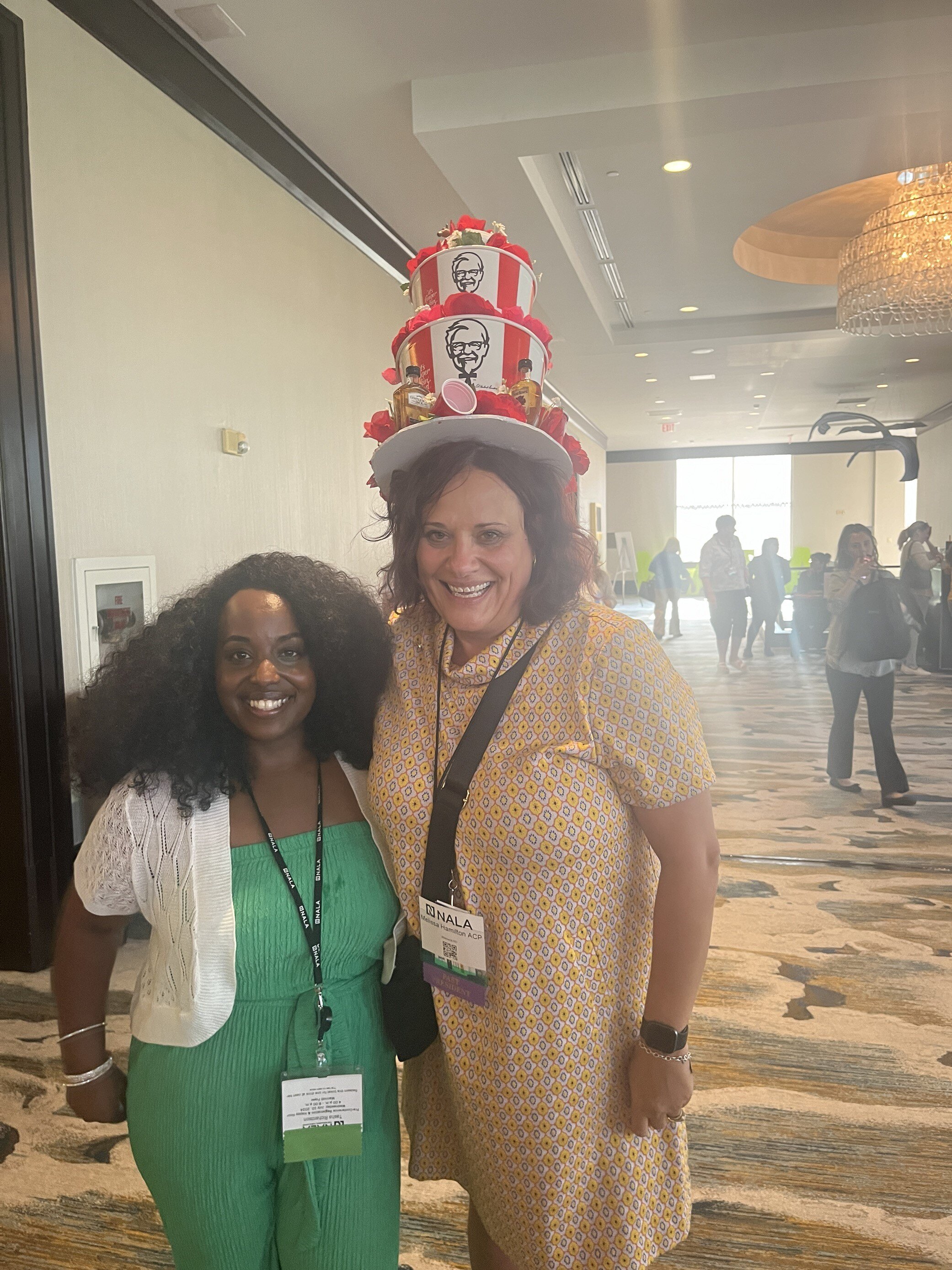 ABC Legal team members smiling with attendees wearing themed hats at NALA Annual Conference.
