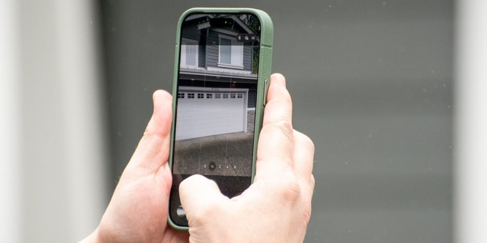 Hands steadying a phone to photograph a residence during a service attempt