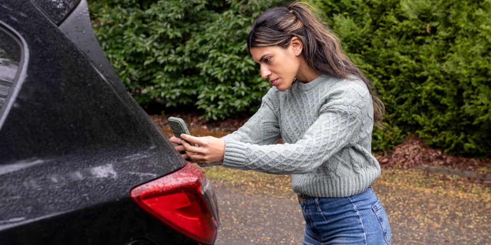 A process server photographing a home's driveway and garage as proof of service